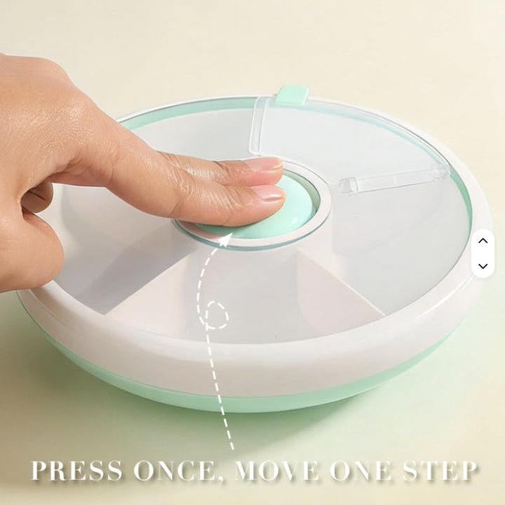Finger pressing the center button on a green rotating snack box