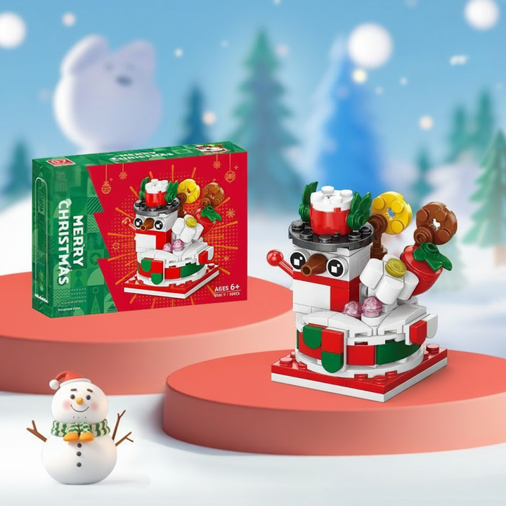 Snowman building model with a black hat and a red and green base beside its box