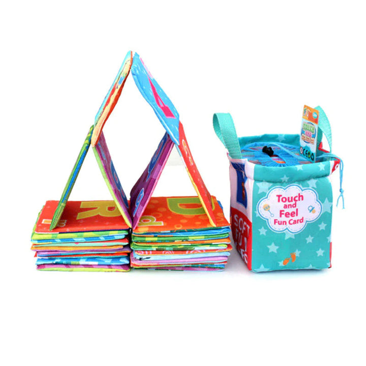 Soft learning books stacked and propped open beside a turquoise storage pouch