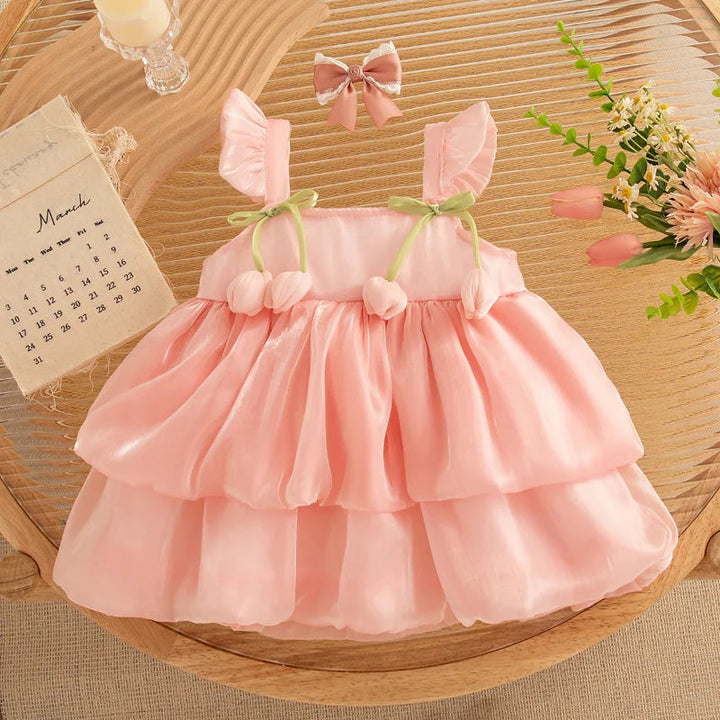 Front of the soft pink tulip dress with ruffled straps and a tiered skirt