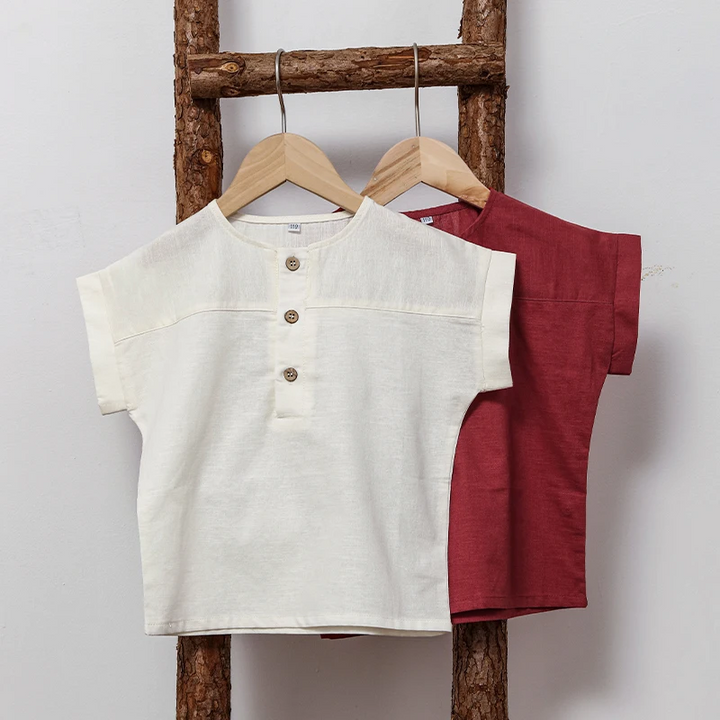 White and red short-sleeve shirts hanging from a wooden ladder