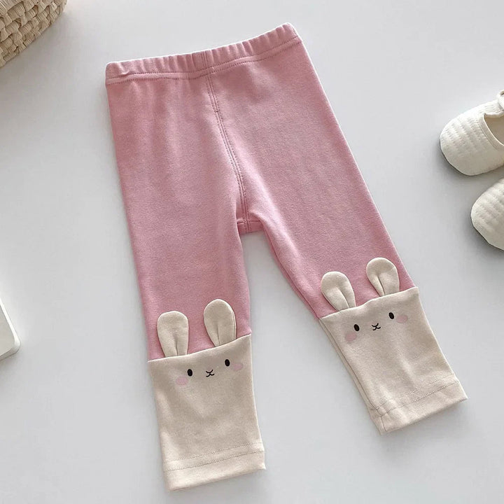Solid pink leggings with cream bunny-face cuffs and raised ears