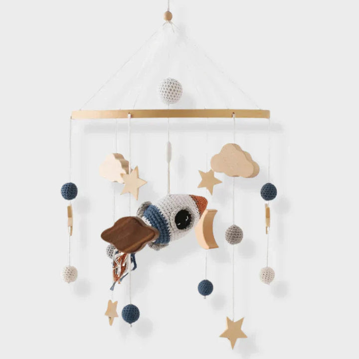 Space baby mobile with a textured rocket, wooden stars, a crescent moon, and clouds