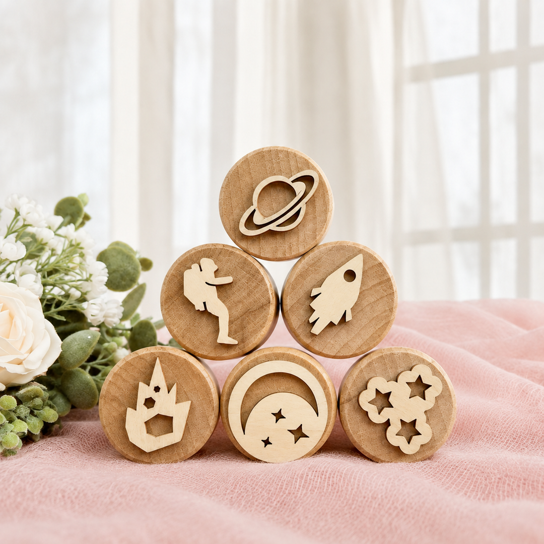 Space-themed wooden clay stamps stacked with a planet, astronaut, rockets, stars, and moon.