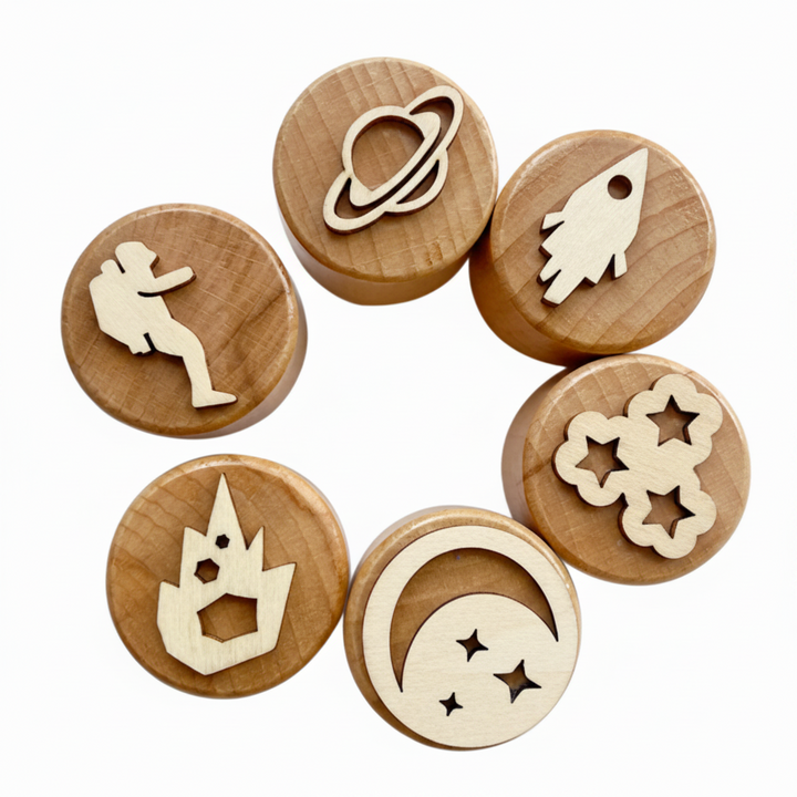 Six space-themed wooden clay stamps with planet, astronaut, rocket, stars, and moon designs.
