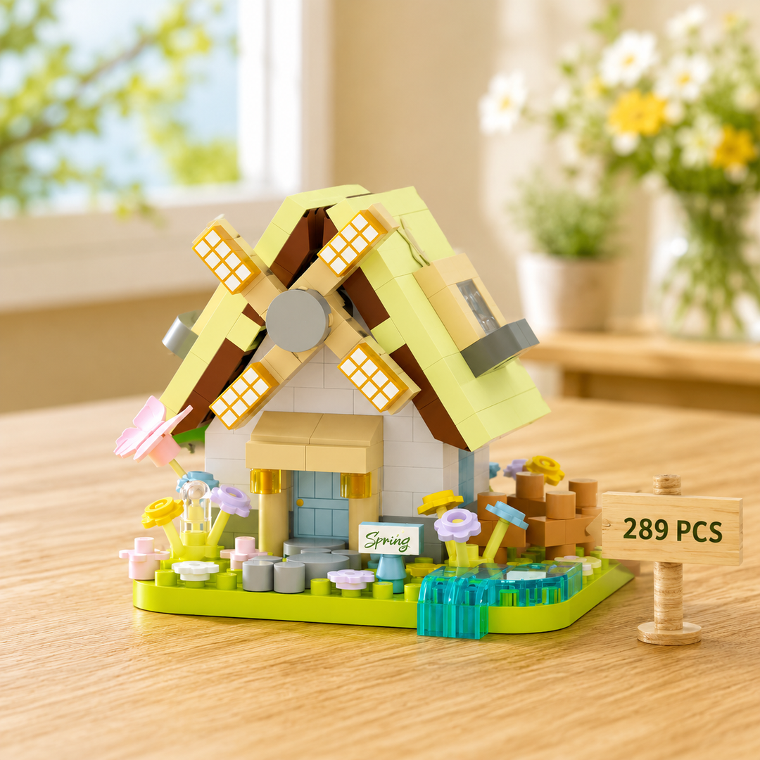 Spring windmill block model with a pale green roof, flowers and a blue stream.