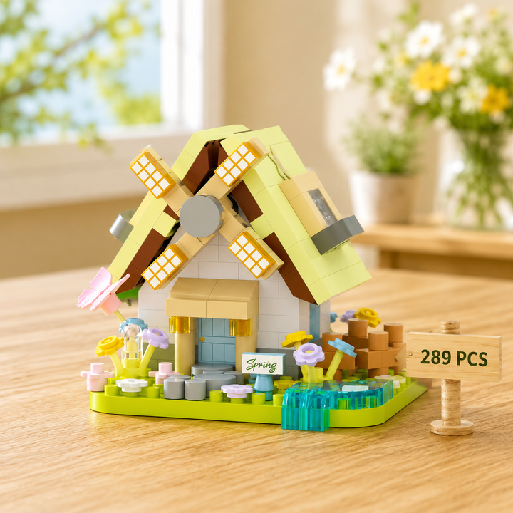 Spring windmill block model with a pale green roof, flowers and a blue stream.