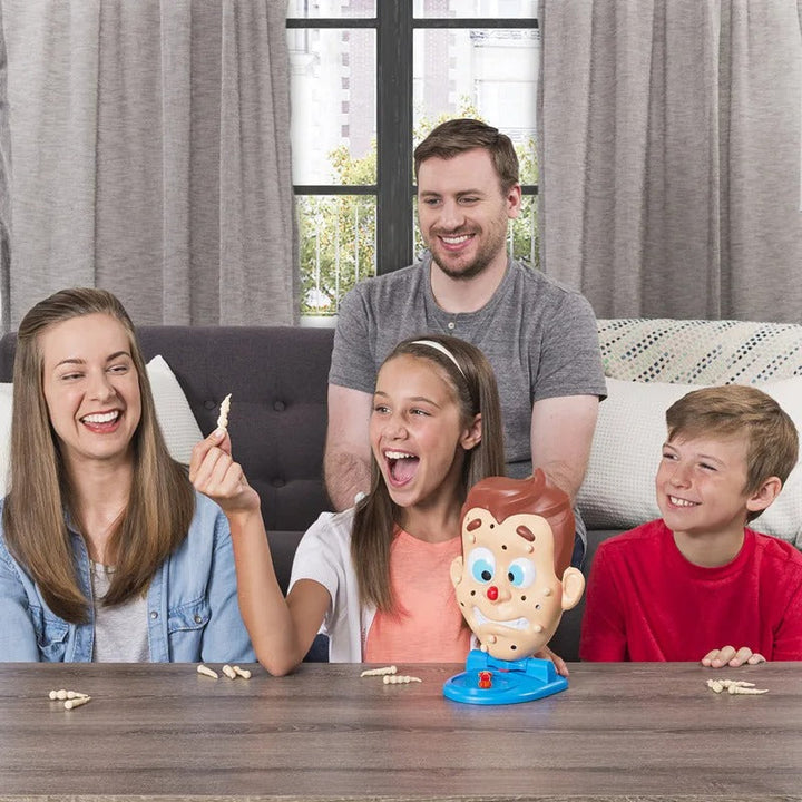 Children and adults sharing the pimple-face game at a table