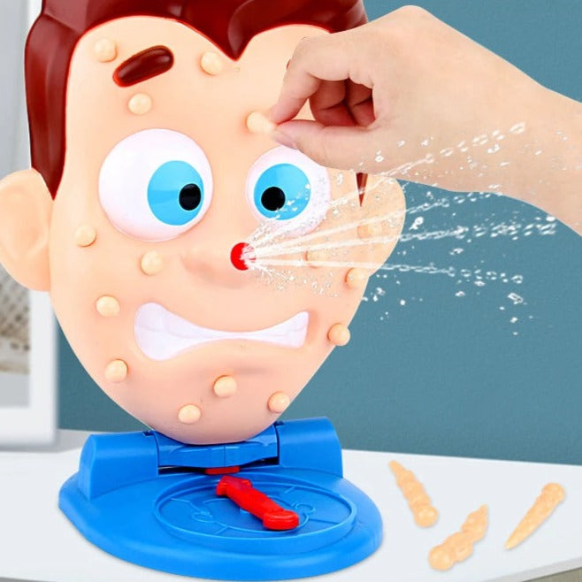 A hand presses a pimple on the cartoon face as water sprays from its red nose