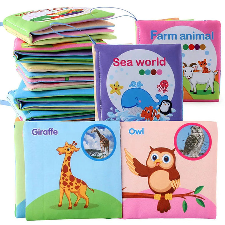 Stacked square fabric books with an open giraffe-and-owl spread and ocean and farm covers.