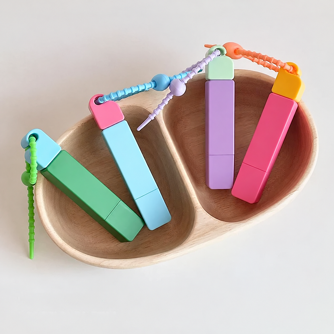Colorful stain remover pens with loop straps arranged in wooden trays