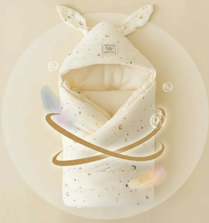 Star-and-moon print swaddle blanket with a bunny-ear hood and decorative curved graphics