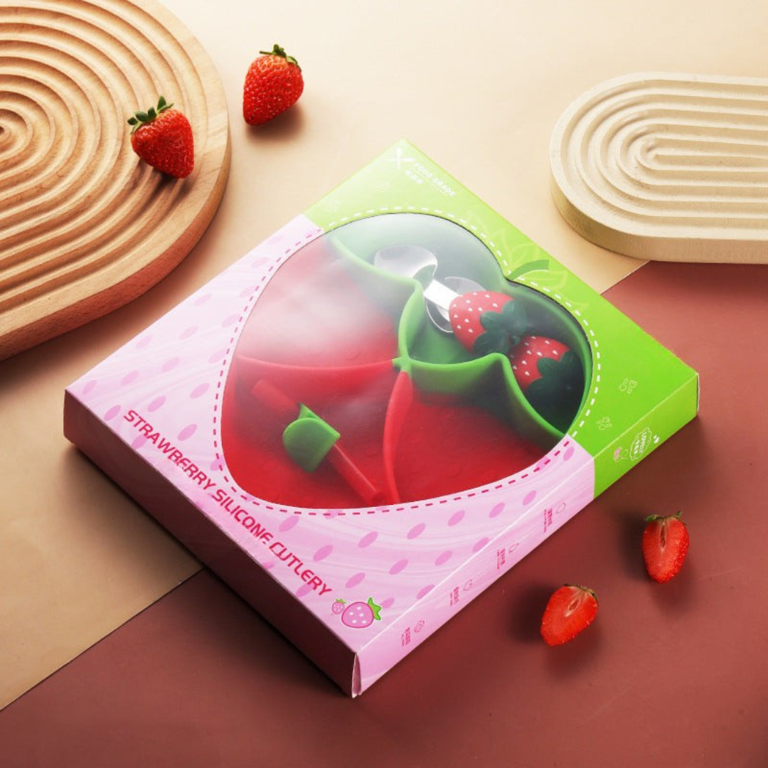 Strawberry-shaped plate and matching cutlery displayed in pink-and-green packaging