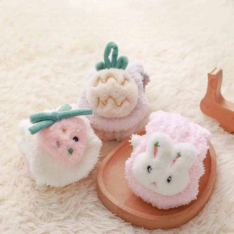 Strawberry, rabbit, and pineapple socks arranged beside a wooden tray