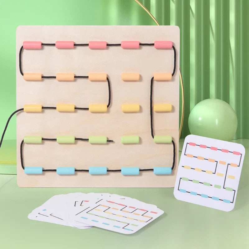 Black cord routed around colorful guides on a wooden board beside a matching pattern card.