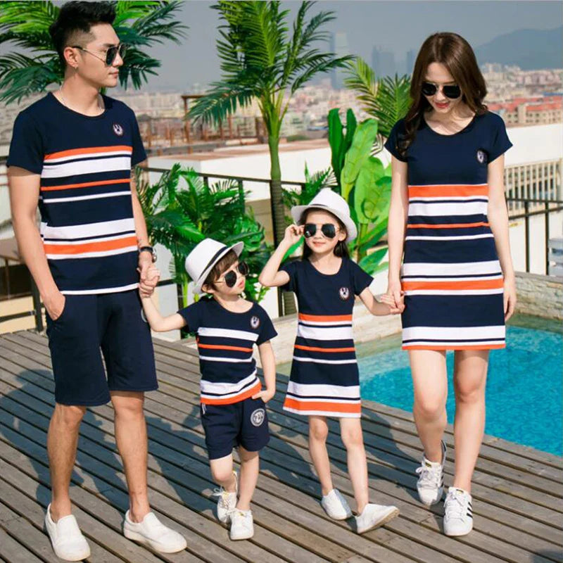Parents walking with two children in coordinated navy striped family outfits