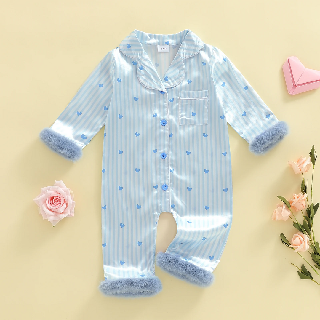 Blue and white heart-print baby jumpsuit laid flat with buttons, a chest pocket, and plush cuffs