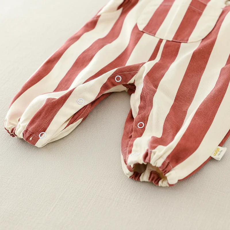 Close-up of snap fastenings and gathered cuffs on the red striped romper legs