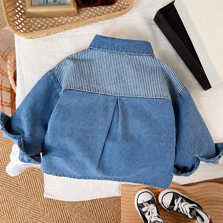 Back of the denim jacket showing a striped shoulder panel and a pleat below it.