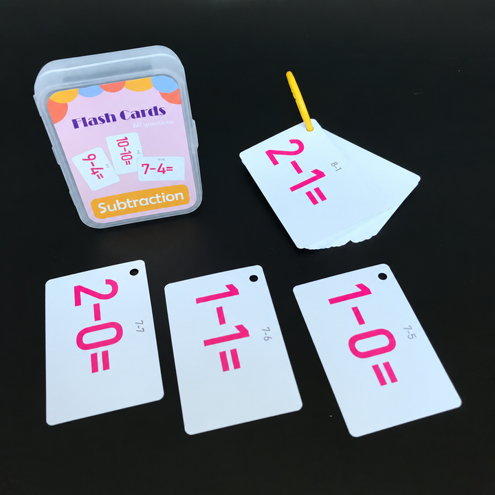 Subtraction flash cards with pink equations displayed beside their case and yellow ring.