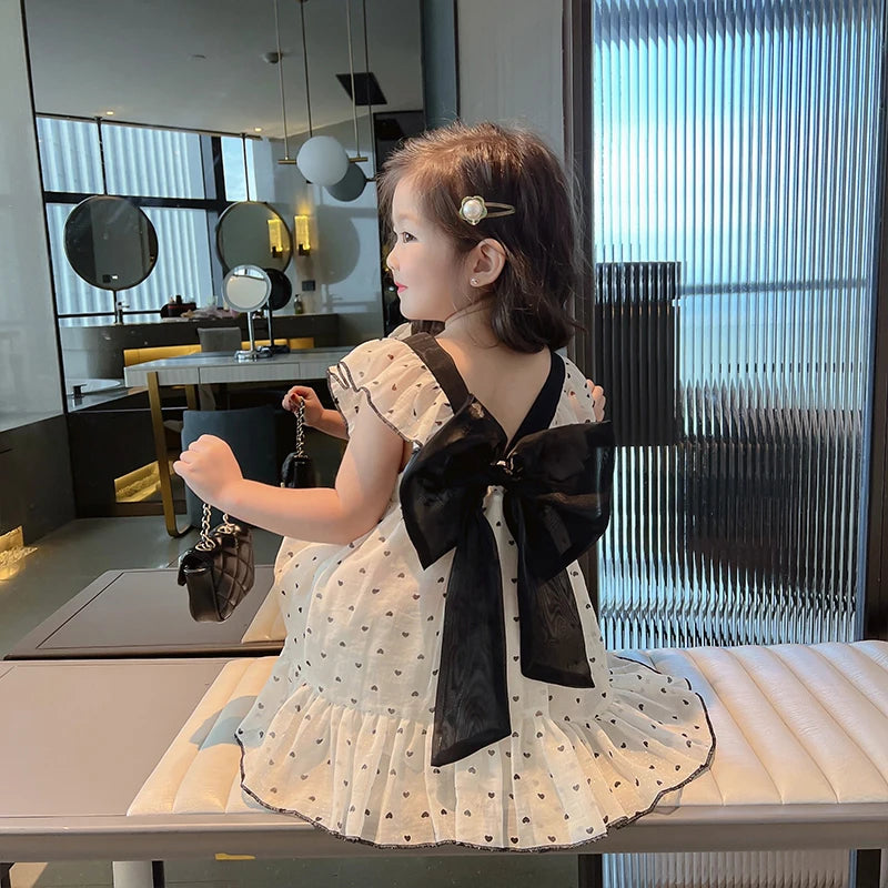 Back of the heart-print dress with black straps and a large black bow