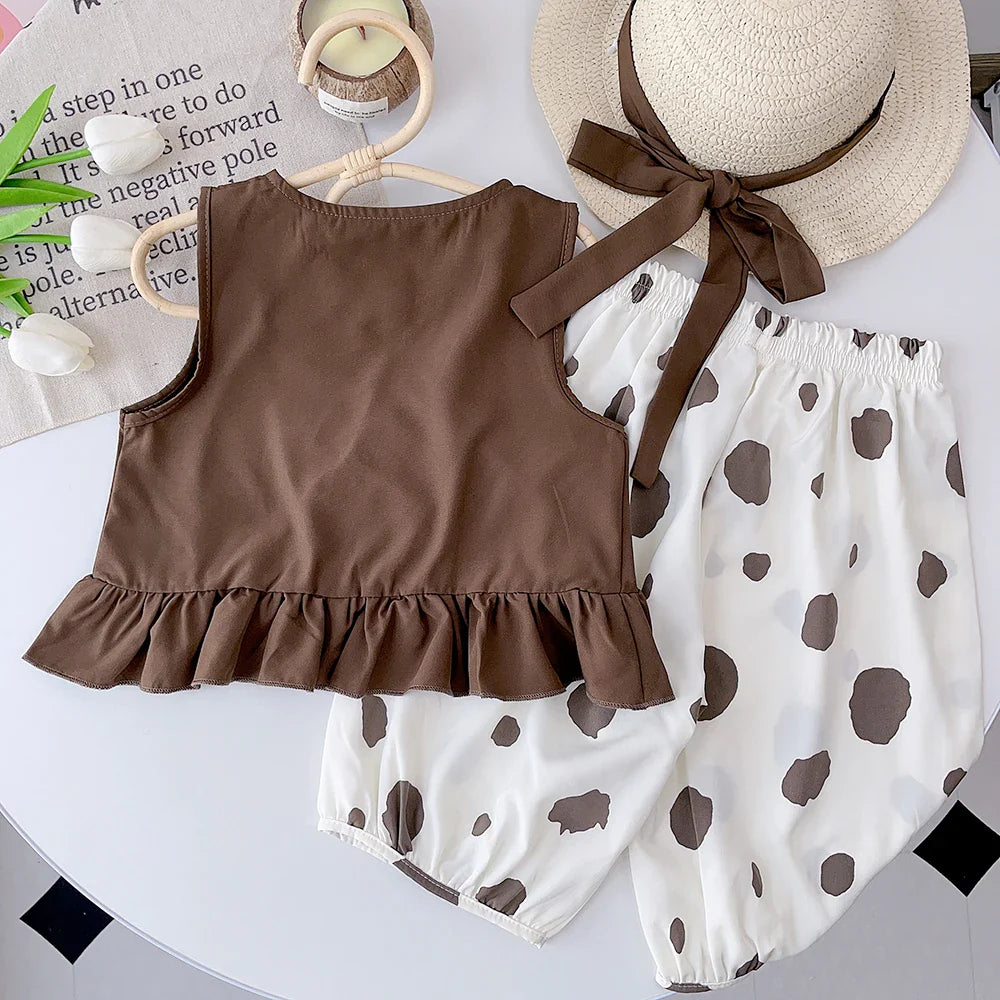 Back of the brown sleeveless top with a ruffled hem beside dotted white bottoms