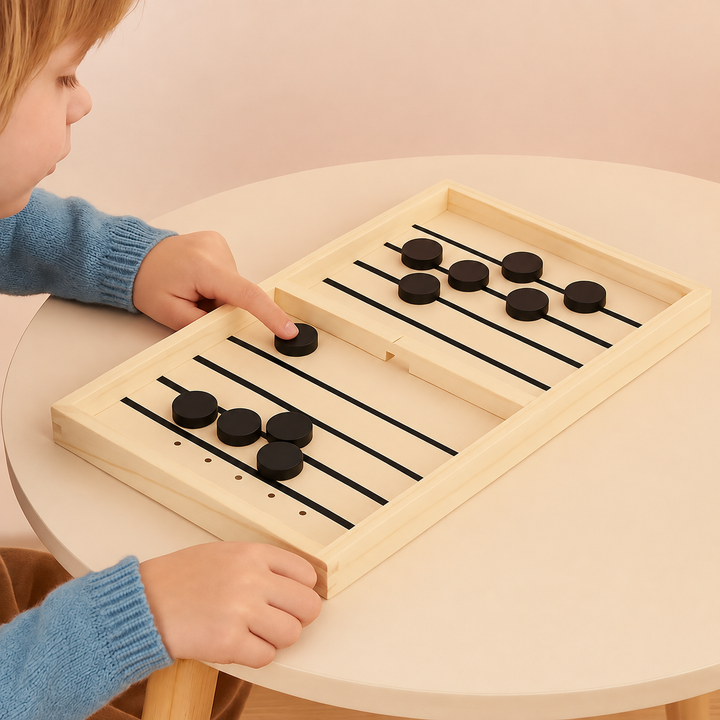 Child aiming a black puck on a wooden sling puck board at a round table