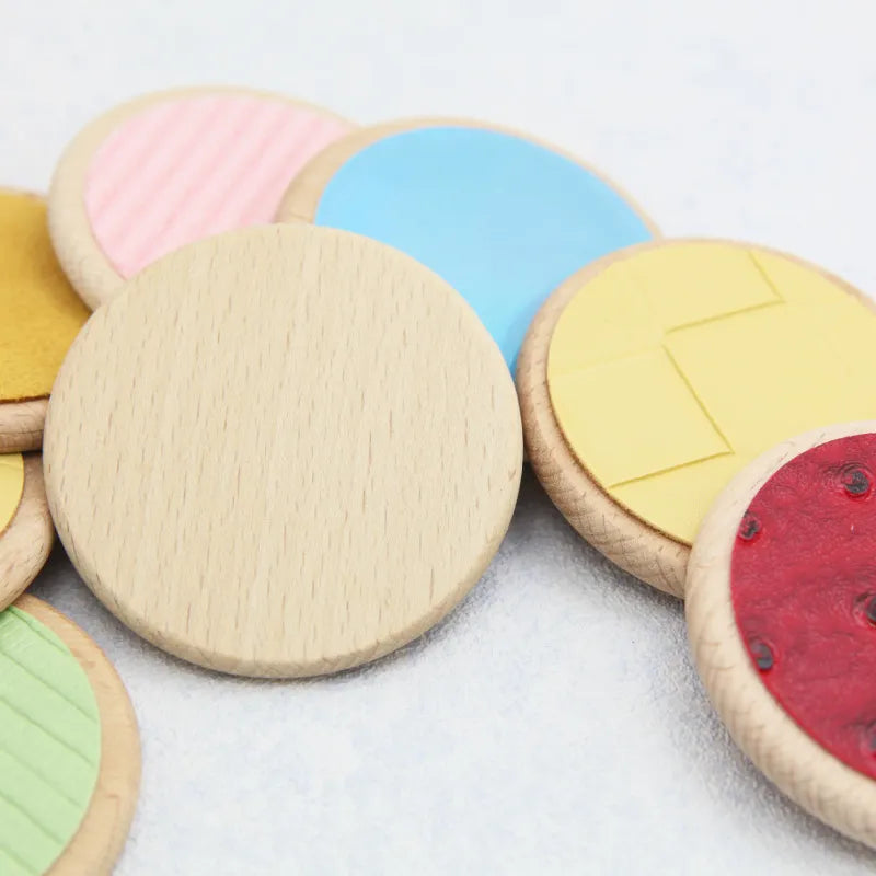 Colored tactile discs with wooden rims and one disc turned over to show its plain wood back