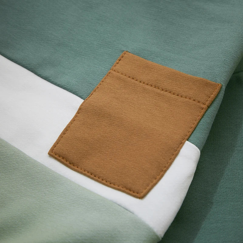 Tan patch pocket stitched over green and white sweatshirt panels