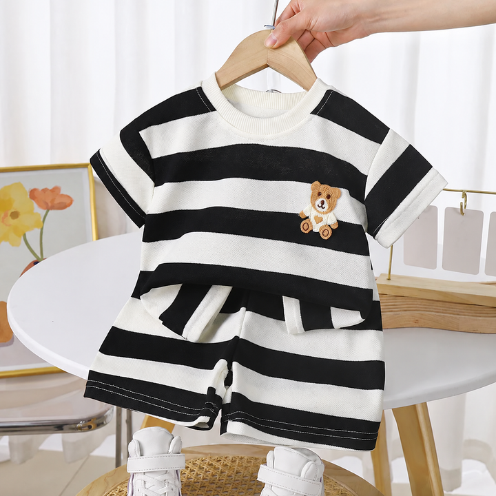 Black-and-cream striped T-shirt and shorts set on a hanger, with a teddy bear detail on the chest