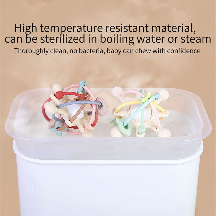 Two silicone teething balls in a translucent container with steam rising