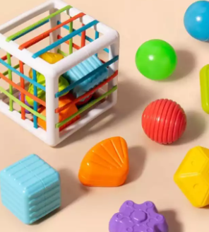 White sorting cube with colorful bands and textured shape blocks arranged around it