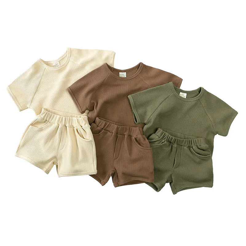 Beige, brown, and green children's T-shirt and shorts sets with textured fabric