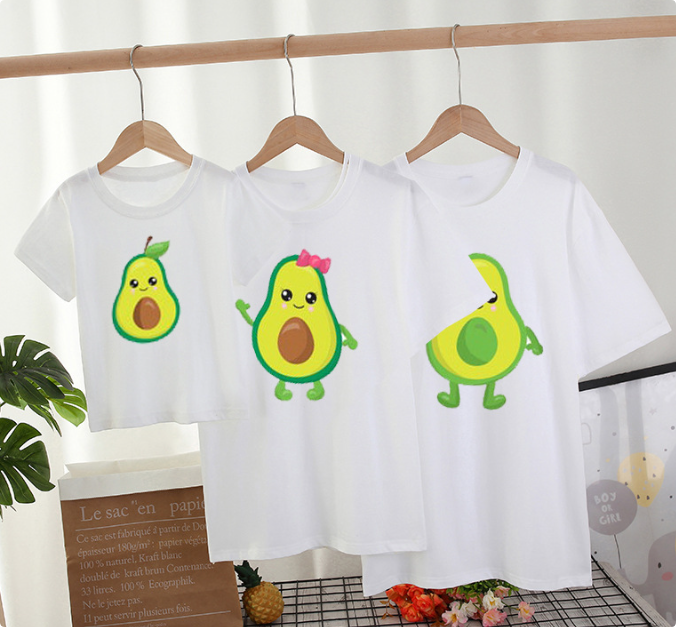 Three white T-shirts with different cartoon avocado designs hanging on wooden hangers