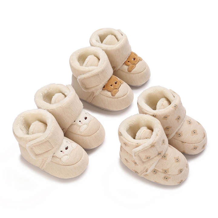 Three pairs of cream baby boots with bear motifs, plush lining and wraparound straps