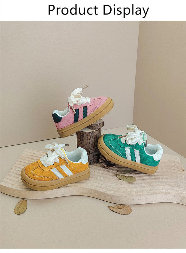 Yellow, pink and green low-top sneakers arranged on a wooden display