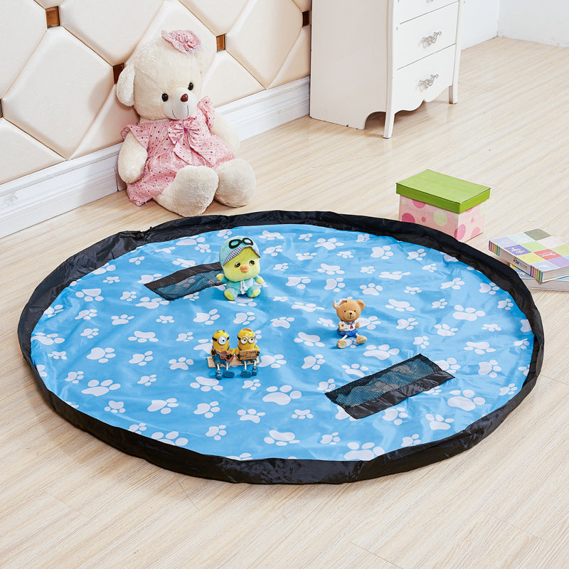 Blue paw-print play mat opened flat with toys and a black drawstring border.