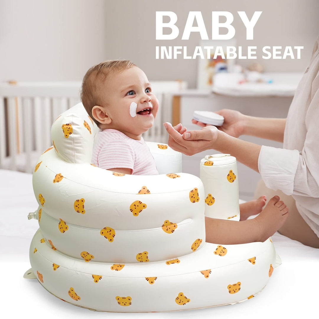 Baby being spoon-fed by an adult while sitting in a tiger-print inflatable seat.
