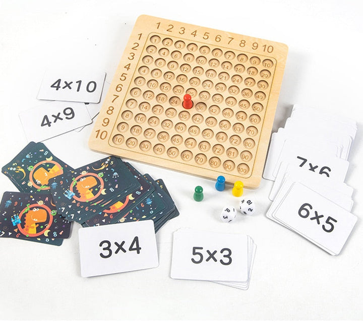 Wooden multiplication board marked 1–10 with math cards, dice, and colored playing tokens