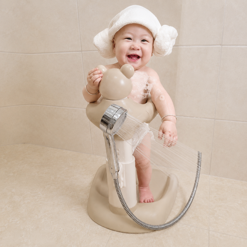 Toddler using the beige bath stand during a shower