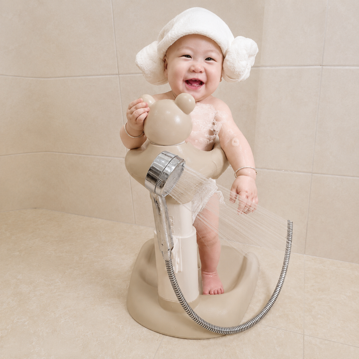 Toddler using the beige bath stand during a shower