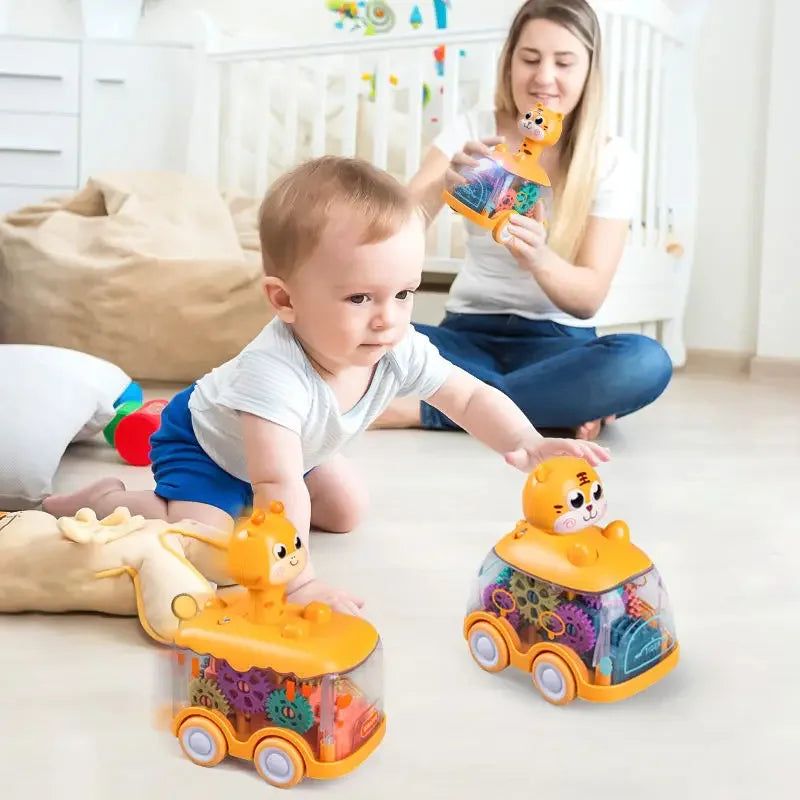 Toddler reaching for clear gear toy cars while an adult sits nearby