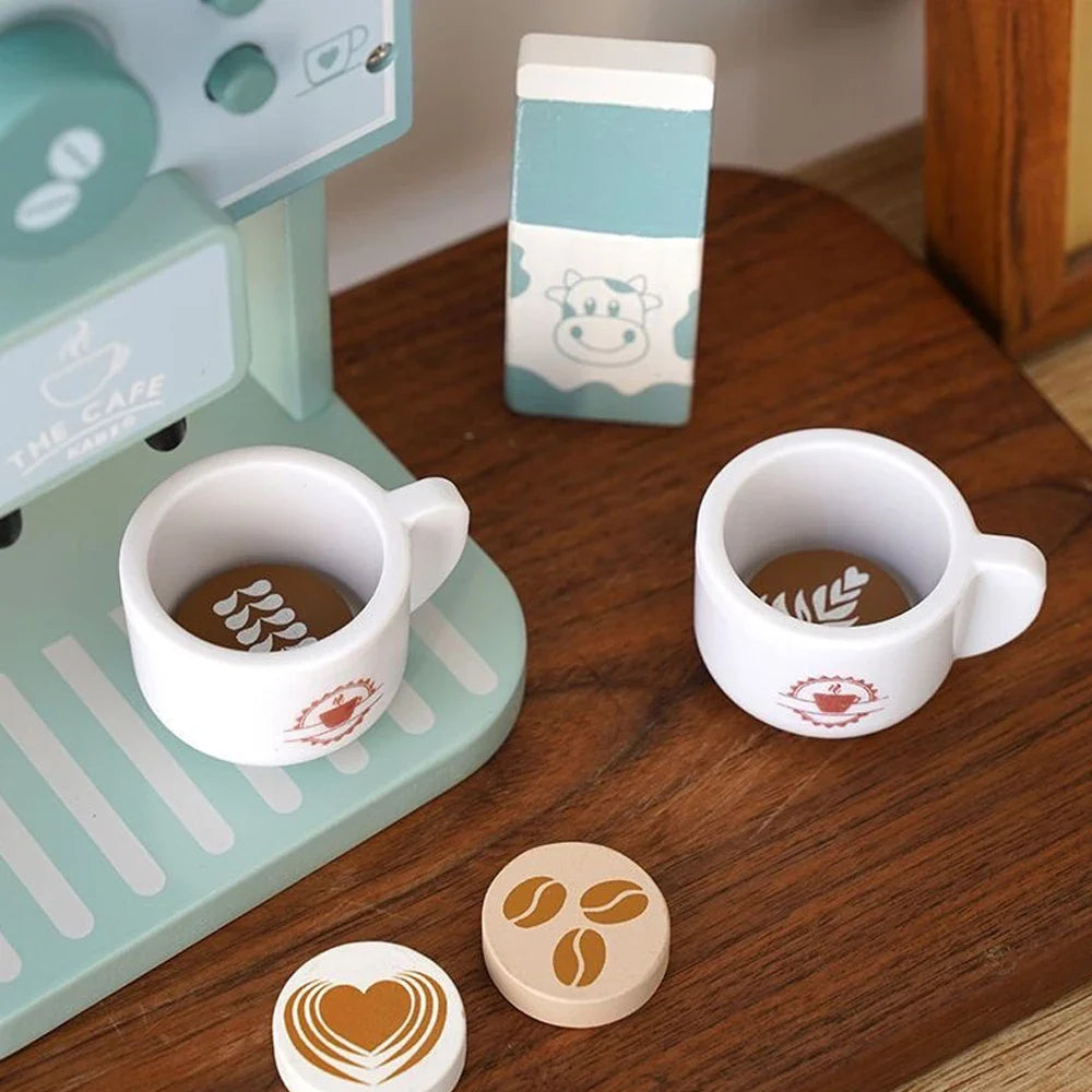 Two toy cups holding coffee-patterned wooden discs beside the play coffee machine
