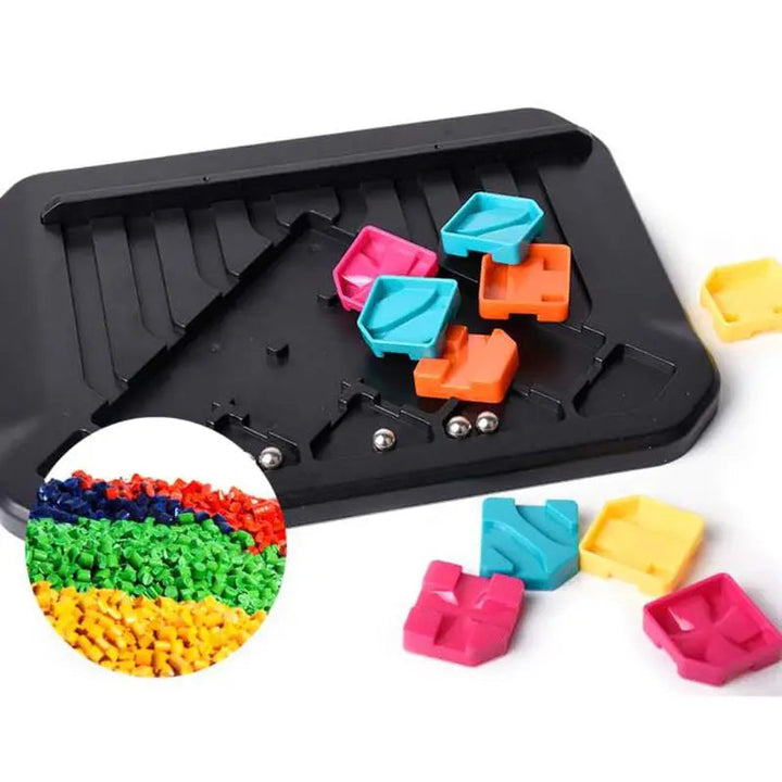 Black track puzzle board with loose colorful pieces and silver-colored balls
