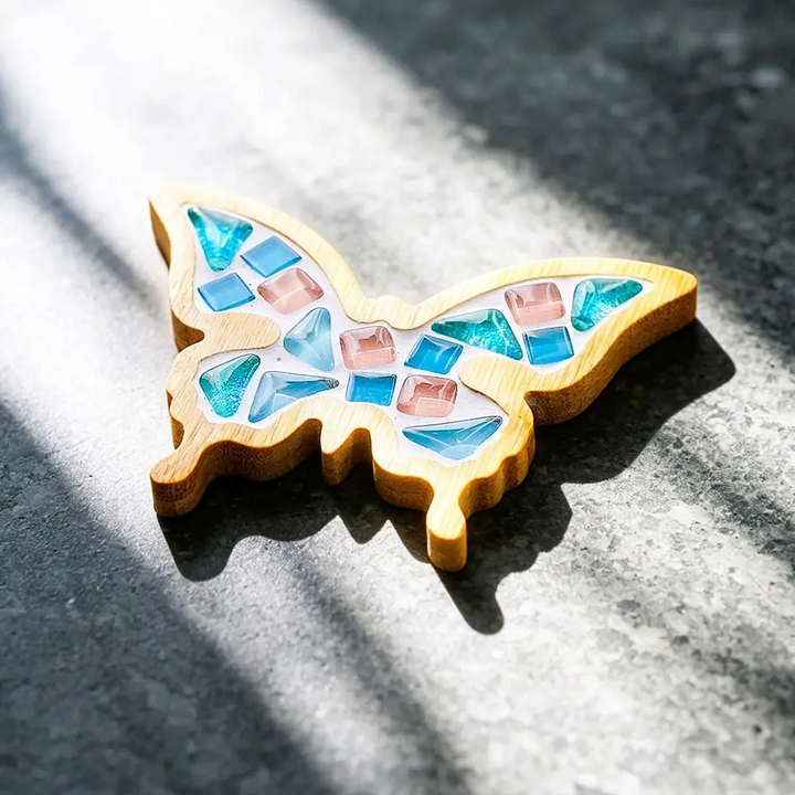 Butterfly-shaped bamboo coaster decorated with turquoise, blue and pink mosaic tiles