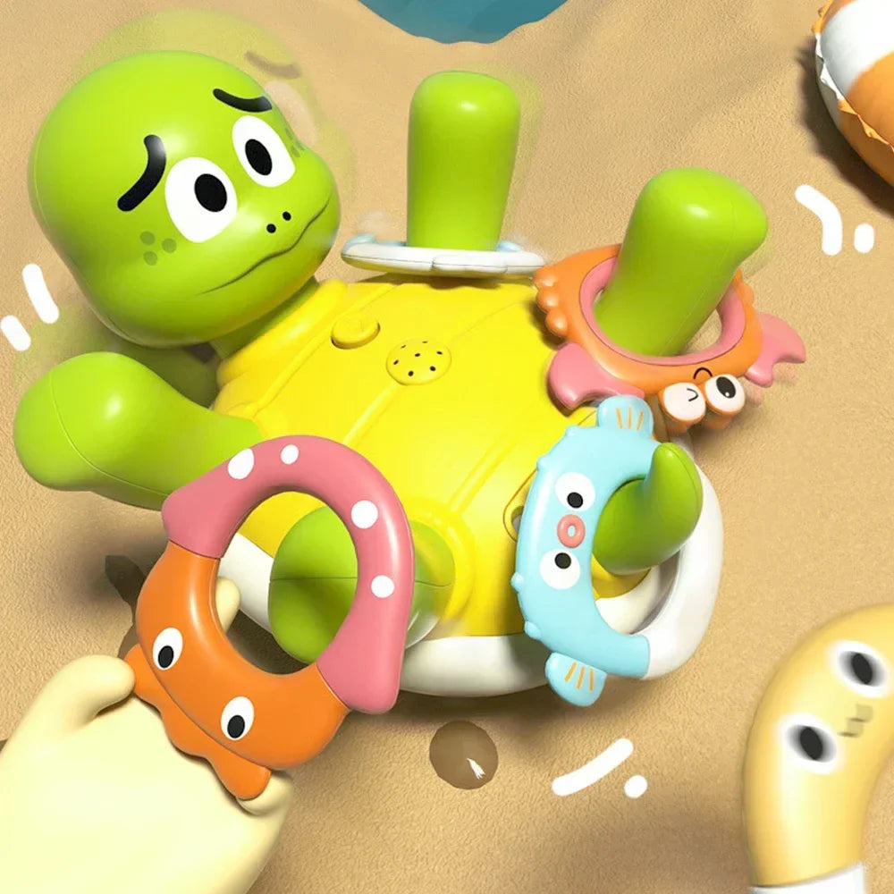 Green turtle bath toy with a yellow belly and colorful animal-shaped rings.