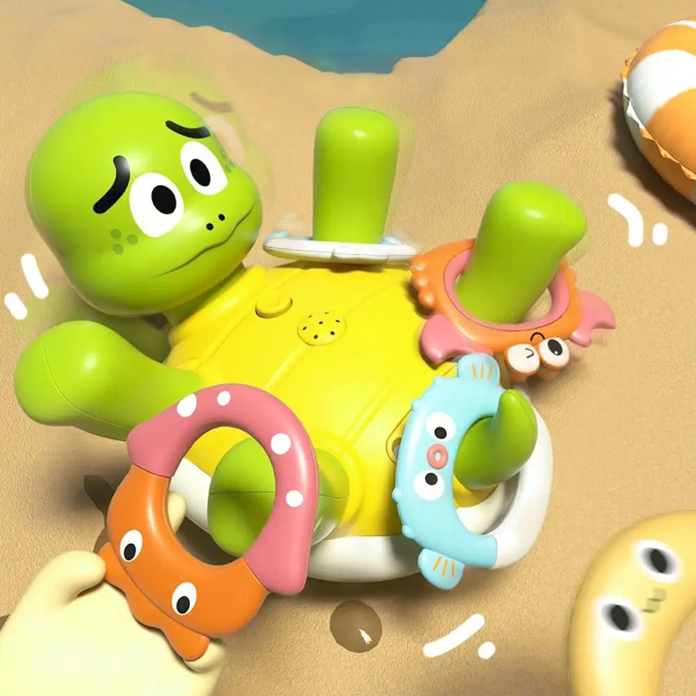 Turtle bath toy with pink, blue, and pale purple animal-shaped rings around its raised limbs.