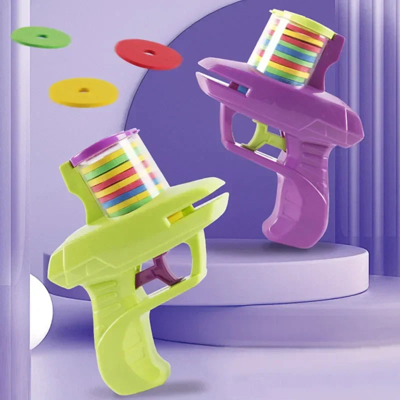Purple and green toy disc blasters displayed with red, yellow, and green foam discs.
