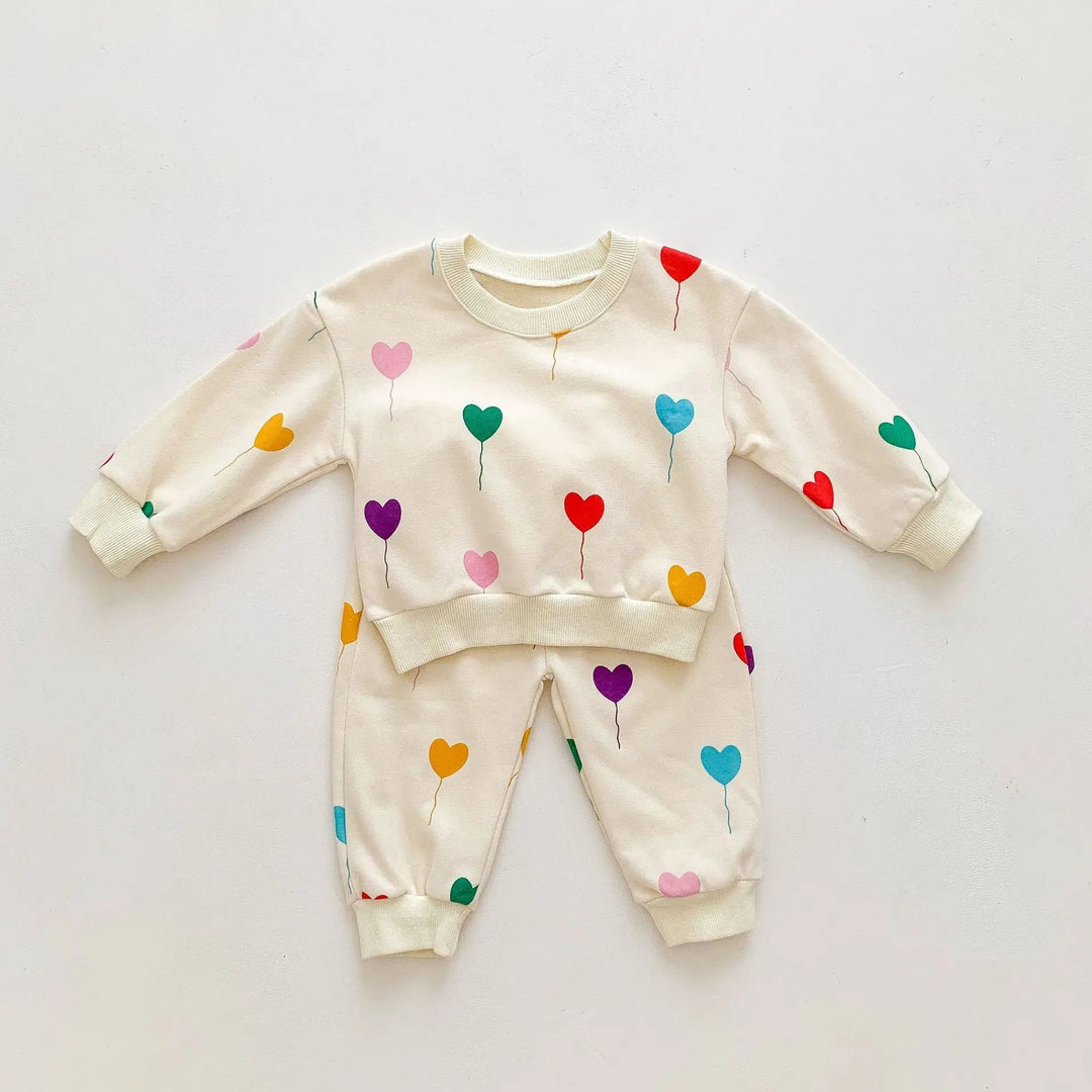 Two-piece cream baby tracksuit with colorful heart balloons, long sleeves and cuffed pants