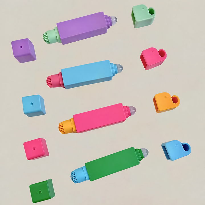 Four colorful stain remover pens laid out with both end caps removed